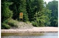 Signs prohibiting swimming are found on the banks of the Rivière Rouge in the Laurentians. Bathers lured by the river's sandy shores have been sucked below by clinging mud and unseen currents.