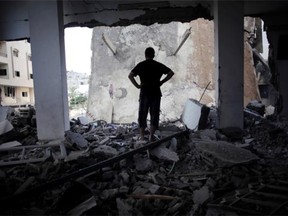 A Palestinian man looks at a destroyed house following an overnight Israeli missile strike in Gaza City Monday, July 14, 2014. Israel began airstrikes Tuesday against militants in the Hamas-controlled Gaza Strip in what it says was a response to heavy rocket fire out of the densely populated territory. The military says it has launched more than 1,300 airstrikes since then, while Palestinian militants have launched nearly 1,000 rockets at Israel.