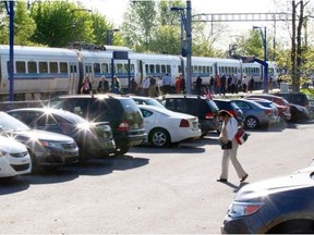 Passengers wait to board an AMT train near one of the parking lots at the Roxboro-Pierrefonds train station in Montreal, Tuesday, May 20, 2014.  The AMT has announced a pilot project that will see a monthly fee attached to a certain number of parking spots at select train stations.