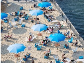 People enjoy an afternoon at the Clock Tower Beach in the Old Port of Montreal on Thursday, July 24, 2014.
