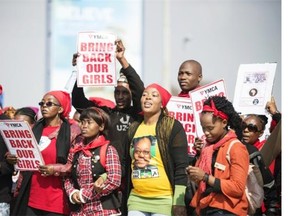 People hold placards as hundreds of Soweto residents gather at the YMCA in Soweto, Johannesbourg, on May 22, 2014, to demonstrate for the release of more than 200 schoolgirls kidnapped by Islamist militant group Boko Haram in Nigeria.