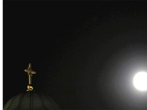 A perigee moon, also known as a supermoon, is seen behind a traditional Serbian orthodox cross on the St. Sava temple, in Belgrade, Serbia, Saturday, July 12, 2014.
