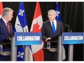 Prime Minister Stephen Harper, right, looks at Quebec Premier Philippe Couillard during an announcement at Roberval, Que., Wednesday June 25 2014.
