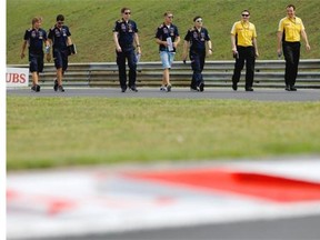 Sebastian Vettel of Germany and Infiniti Red Bull Racing walks the track with his team during previews ahead of the Hungarian Formula One Grand Prix at Hungaroring on July 24, 2014 in Budapest, Hungary.