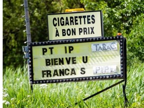 A sign advertising cigarettes and tobacco products on Highway 132 on Kahnawake Mohawk territory on Wednesday, July 9, 2014. The Mohawk Council of Kahnawake will regulate the sale of illicit tobacco on the south shore reserve.