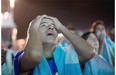 A soccer fan of the Argentina national soccer team holds his head with his hands during a live broadcast of the soccer World Cup final match between Argentina and Germany, inside the FIFA Fan Fest area on Copacabana beach, in Rio de Janeiro, Brazil, on Sunday. Mario Goetze scored the winning goal in extra time to give Germany its fourth World Cup title with a 1-0 victory over Argentina.