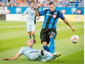Sporting Kansas City’s Aurelien Collin slides in as he tries to block the pass to Montreal Impact’s Krzysztof Krol during first half MLS action in Montreal on Saturday.