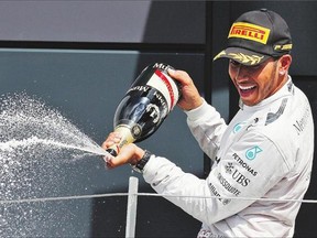 Lewis Hamilton sprays his technicians with champagne after winning the British Formula One Grand Prix at Silverstone England on Sunday, July 6, 2014.