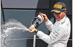 Lewis Hamilton sprays his technicians with champagne after winning the British Formula One Grand Prix at Silverstone England on Sunday, July 6, 2014.