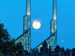 A supermoon rises over the Oregon Convention Center in Portland, Ore, Saturday, July 12, 2014.