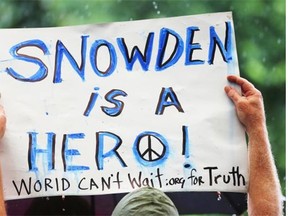 A supporter holds a sign at a small rally on behalf of National Security Administration (NSA) whistleblower Edward Snowden in New York City in June 2013. Alberta’s Whistleblower Protection Act is flawed legislation that doesn’t truly protect civil servants, the Journal writes in an editorial.