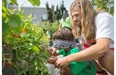 Urban agriculture intern at Santropol Roulant Marc Antoine Fortin teaches a child to identify plants with touch during an urban agriculture workshop for children at the Santropol Roulant building in Montreal.