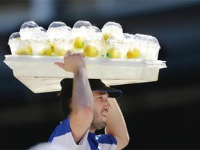 A vendor carries a full tray of ice-cold lemonade on his head during a baseball game between the Seattle Mariners and the Baltimore Orioles, Sunday, July 27, 2014, in Seattle. The drinks were selling well on the sunny day as temperatures approached 80.