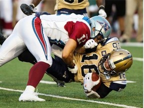 Winnipeg Blue Bombers quarterback Robert Marve is tackled by Montreal Alouettes linebacker Chip Cox during second quarter CFL football action Friday, July 11, 2014 in Montreal. T