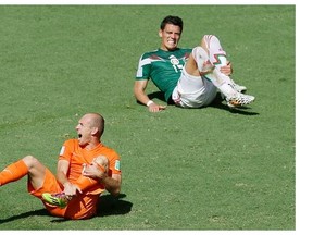 The World Cup has seen its share of Shakespearean performances by falling players howling in pain to impress the referee. Here, The Netherlands’ Arjen Robben, left, and Mexico’s Hector Moreno put on the act.