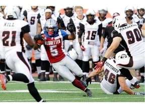 Alouettes kick-returner Larry Taylor is surrounded by Redblacks players T.J. Hill, Andrew Marshall and Jason Pottinger in the first half of a pre-season CFL game at Molson Stadium in June.