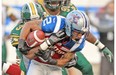 Alouettes running back Brandon Whittaker struggles to hold onto the ball while being tackled by Eskimos’ Eric Samuels at Molson Stadium in Montreal on Friday, Aug. 8, 2014.