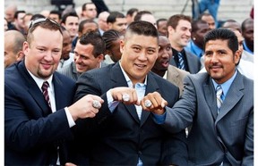 Bryan Chiu was flanked by then-teammates Scott Flory, left, and Anthony Calvillo as they showed off their show off their CFL Championship rings during a ceremony in 2010. (Dario Ayala /Gazette files)