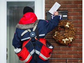 A Canada Post mailman delivers mail in the borough of Villeray-Saint-Michel-Parc-Extension in Montreal on Wednesday, December 11, 2013.