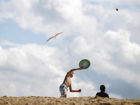 Children play on a beach in Ouistreham, northwestern France, on August 20, 2014 during the “Forgotten by the Holidays” campaign organised by the French NGO Secours Populaire for children whose families can’t afford to go on holidays.