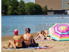 A couple applies sunscreen at the beach at Jean-Drapeau Park in Montreal on Sunday, June 15, 2014. The beach had its first weekend of the summer on Saturday, June 14.