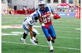 Duron Carter of the Alouettes runs with the ball past Shea Emry of the Toronto Argonauts during the CFL game at Percival Molson Stadium on August 1, 2014 in Montreal.