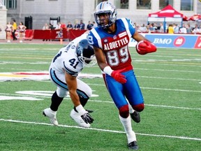 Duron Carter of the Alouettes runs with the ball past Shea Emry of the Toronto Argonauts during the CFL game at Percival Molson Stadium on August 1, 2014 in Montreal.