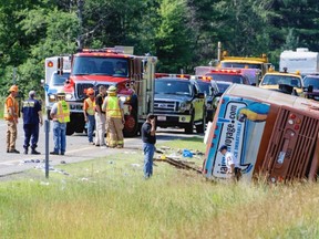 Emergency personnel attend to a victim after a bus accident on Interstate 87, also known as the Adirondack Northway, in North Hudson, N.Y. on Friday July 18, 2014. New York State Police Department investigators say they found no mechanical defect in the Quebec tour bus.