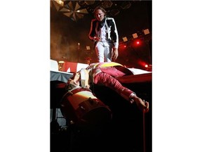Win Butler of the Montreal band Arcade Fire looks down at a "collapsed" drummer figure with a papier mache head during the band's concert at Parc Jean-Drapeau in Montreal on Saturday.
