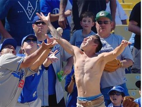 Fans try to catch a foul ball hit by Los Angeles Dodgers' Carl Crawford during the eighth inning of a baseball game against the Milwaukee Brewers, Sunday, Aug. 17, 2014, in Los Angeles. The Brewers won 7-2.