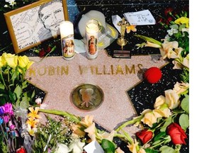 Flowers are placed in memory of actor/comedian Robin Williams on his Walk of Fame star in the Hollywood district of Los Angeles, Monday, Aug. 11, 2014. Williams, a brilliant shapeshifter who could channel his frenetic energy into delightful comic characters like Mrs. Doubtfire or harness it into richly nuanced work like his Oscar-winning turn in Good Will Hunting, died Monday in an apparent suicide. He was 63. Williams was pronounced dead at his San Francisco Bay Area home Monday, according to the sheriff’s office in Marin County, north of San Francisco.