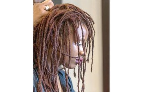 Hairstylist Yvonne Jacobs redoes the dreadlocks on her daughter Sharelle Jacobs at her salon, Eve Coiffure. “I feel good about myself, I feel like this is who I was supposed to be,” Sharelle Jacobs says.