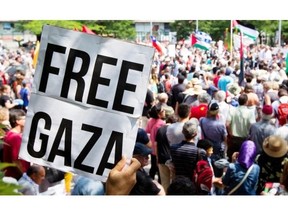 A man holds a Free Gaza sign as he joins several thousand people taking part in a march to protest the living conditions in Gaza and the ongoing conflict with Israel. The group marched throughout the streets of Montreal on Sunday August 10, 2014.