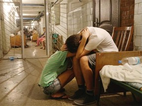 Local residents cry and hug each other as they sit in a hospital basement being used as a bomb-shelter after shelling, in Donetsk, eastern Ukraine, Thursday, Aug. 7, 2014. Fighting in the rebel stronghold of Donetsk claimed more civilian casualties, bringing new calls from Russian nationalists for President Vladimir Putin to send in the army.