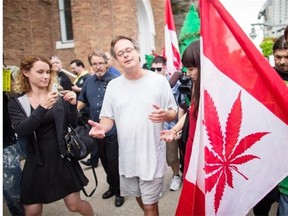 Marc Emery and his wife Jodie are surrounded by media and well wishers as they walk near the border crossing in Windsor, Ontario, Tuesday, August 12, 2014. Canada’s self-styled “Prince of Pot” has returned home after serving his U.S. sentence for selling marijuana seeds to customers across the border.