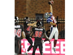 Montreal Alouettes Chip Cox knocks down pass intended for Ottawa Redblacks Matt Carter as Dobson Collins watches during Canadian Football League game in Montreal, Friday August 29, 2014.