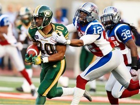Montreal Alouettes Geoff Tisdale, 12, grabs Edmonton Eskimos John White from behind during Canadian Football League in Montreal Friday August 08, 2014.  Alouettes Jerald Brown pursues at right.