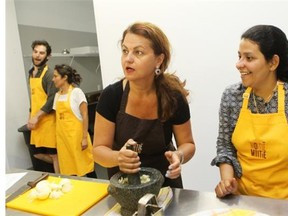 MONTREAL, QUE.: JUNE 10, 2014 — Souha Hatem, centre of photo, makes a paste of garlic and salt using a mortar and pestle, at an Egyptian cooking workshop in June. To her right is guest cook and teacher Shahira Daoud, who gave the workshop at moitié-moitié, an organization founded by Tania Jiménez to bridge the gap between native Quebecers and new Quebecers through cooking workshops and other food vehicles. (Marie-France Coallier/ THE GAZETTE) ORG XMIT: 50146