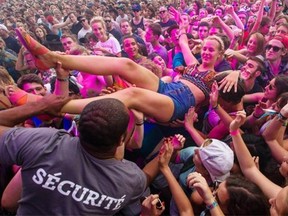 A music fan crowd surfs during the performance by indie rock band Modest Mouse at the 2014 Osheaga Music Festival at Jean-Drapeau Park in Montreal on Saturday.