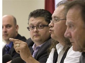 Pierre Bolduc gestures while responding to Superior Court Judge Claude Bouchard's ruling as Frank Tremblay, left, and Roger Lessard look on, Thursday July 11, 2014, in Quebec City. On July 10, Quebec Superior Court judge Claude Bouchard awarded the victims between $75,000 and $150,000 each in compensation.