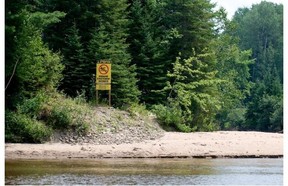 Signs prohibiting swimming are found on the banks of the Rivière Rouge in the Laurentians.
