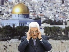 Palestinian president Mahmud Abbas recites a prayer in memory of those killed during the Israeli military offensive on the Gaza Strip, ahead of a press conference on August 26, 2014 in the West Bank city of Ramallah, to formally announce that a deal had been reached with Israel over a long-term end to seven weeks of fighting in Gaza. Israel has agreed to observe an "unlimited" ceasefire in the Gaza Strip, a senior official told AFP, shortly after the deal was announced by the Palestinians.