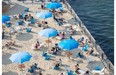 People enjoy an afternoon at the Clock Tower Beach in the Old Port of Montreal on Thursday, July 24, 2014.