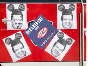 Posters of Montreal Mayor Denis Coderre wearing a Mickey Mouse hat placed on the door of a SIM firetruck in protest of the proposed Bill 3, a pension reform bill, as it’s parked on Rene-Levesque boulevard in Montreal on Tuesday, August 5, 2014.