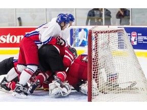 The puck squirts out behind the net while Team Canada and Czech Republic players pile up at Ed Meagher Arena at Concordia University Loyola Campus in Montreal, on Friday, August 8, 2014, during 1st period action at an exhibition game in preparation for this year’s World Junior Hockey Championship.