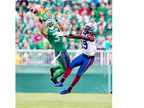 Roughriders’ Macho Harris intercepts a pass in front of Alouettes receiver S.J. Green, who was held to one catch for 15 yards in the contest on Saturday.