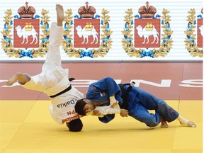 Russia's judoka Beslan Mudranov (blue) competes with Japan's Naochisa Takato during the under 60 kg category semi-final at the IJF World Judo Championship in Chelyabinsk on August 25, 2014.