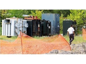 A security guard walks past electrical transformers stored in the yard at Reliance Power Equipment in Pointe Claire, west of Montreal Friday August 30, 2013.