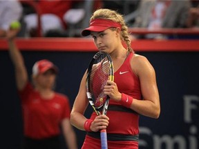 Eugenie Bouchard rests her chin on her raquet after losing a point during her match against American Shelby Rogers at the Rogers Cup tennis tournament in Montreal Tuesday August 05, 2014. Bouchard lost the match in three sets.