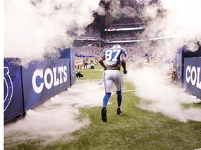In this Aug. 23, 2014, photo, Indianapolis Colts wide receiver Reggie Wayne runs from the tunnel before an NFL preseason football game against the New Orleans Saints in Indianapolis. With a deep group of receivers, two workhorse running backs, two versatile tight ends who can stay on the field for each play and a more confident defense, the defending AFC South champs may finally have the right combination to challenge perennial AFC favorites Denver and New England for the conference championship.